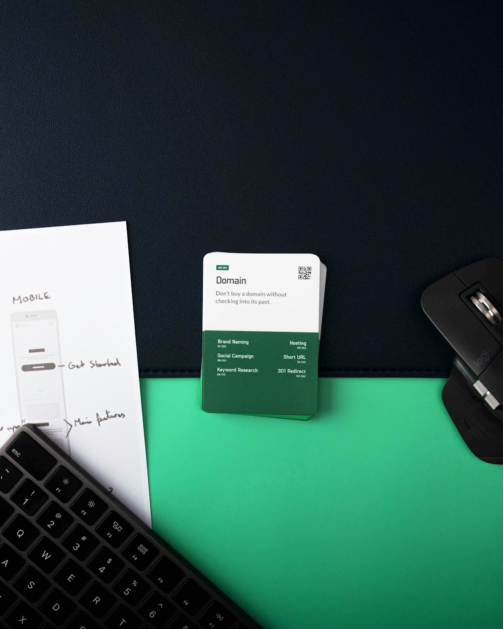 a keyboard, mouse, and business card on a desk