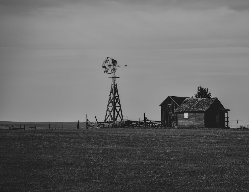 Una foto en blanco y negro de un molino de viento y un granero