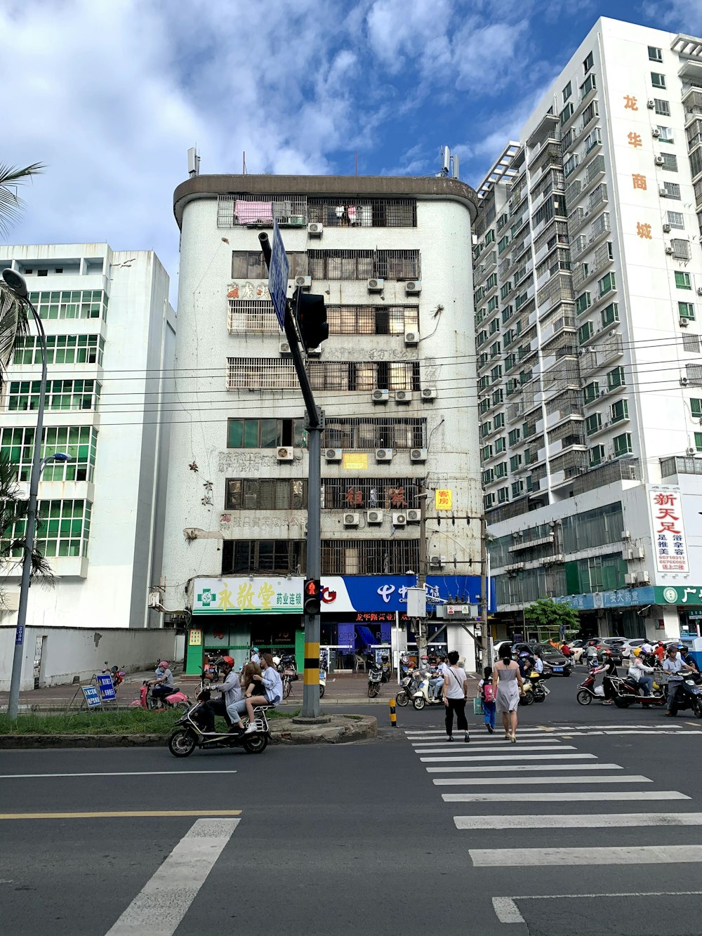 a group of people crossing a street in front of a tall building