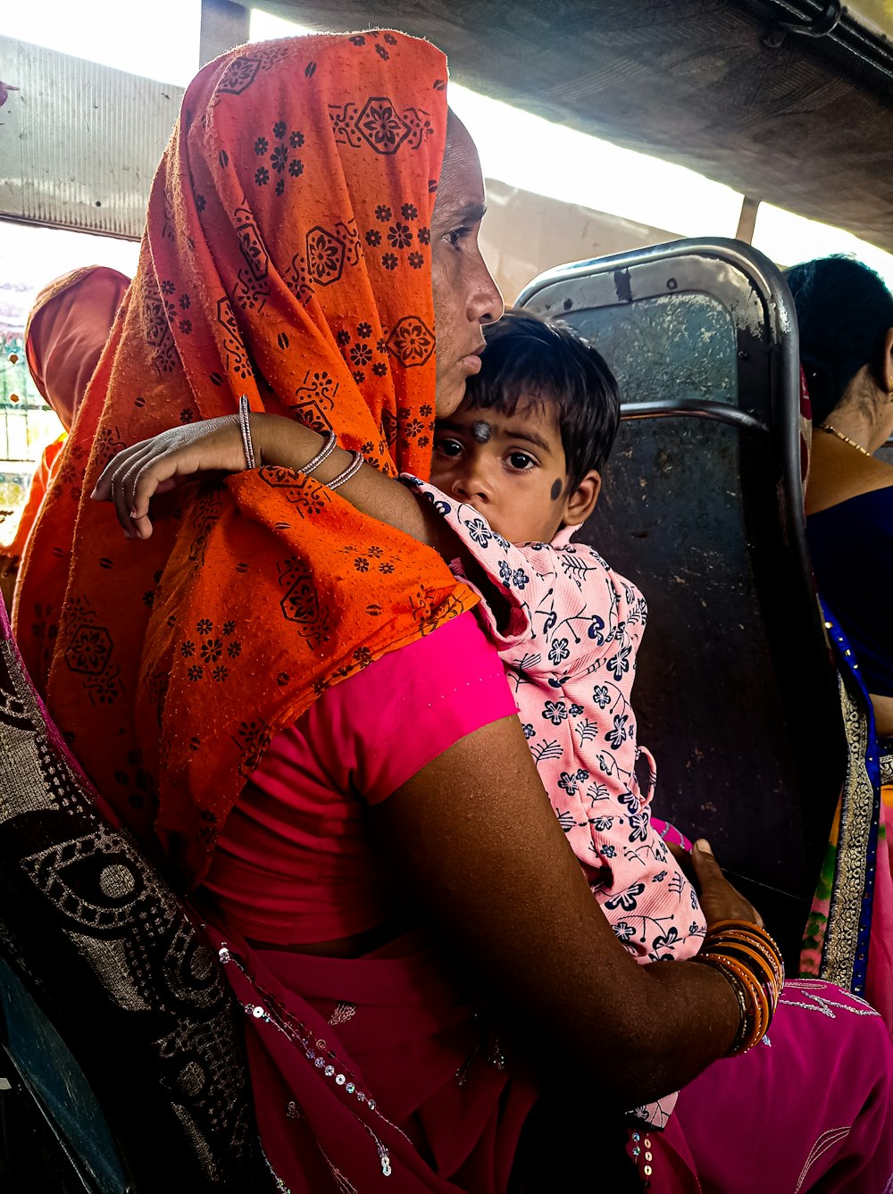 a woman with a child in her arms on a bus