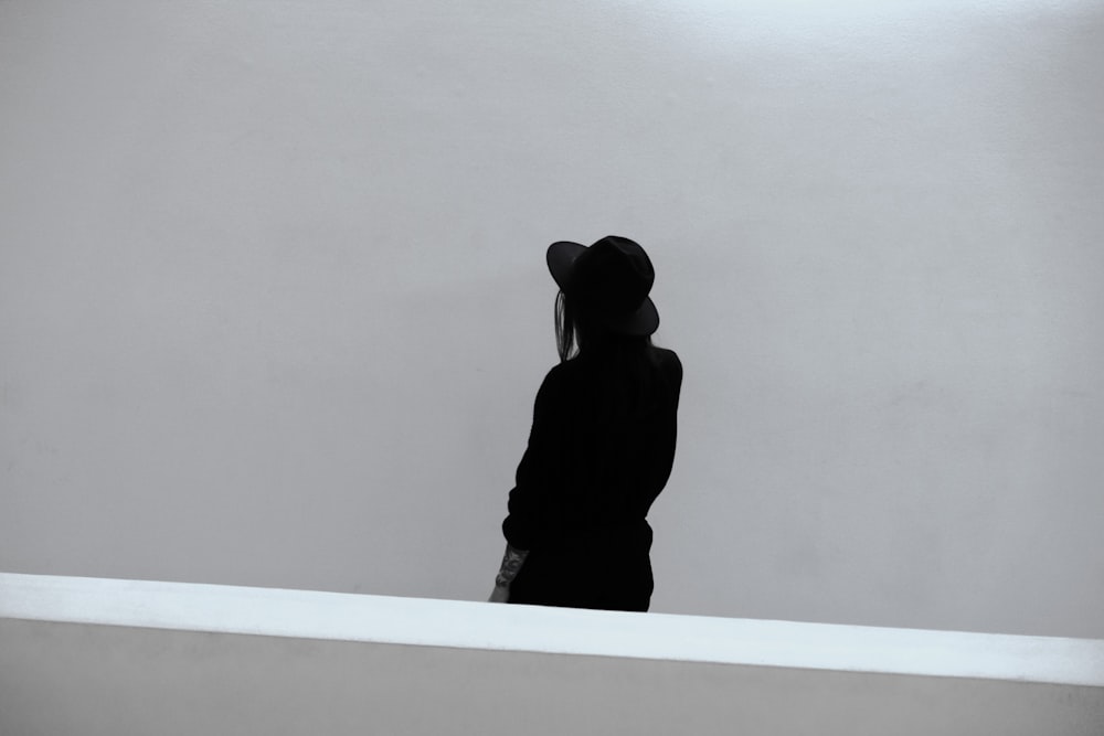 a person standing in a room with a hat on their head