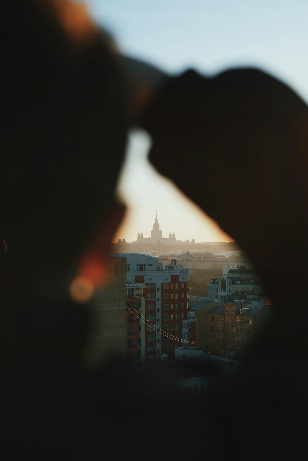 a person looking out a window at a city