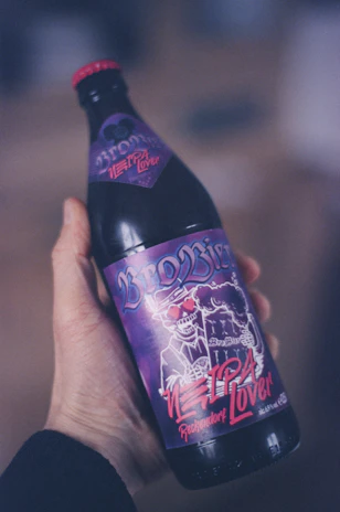 A playful Spartan-themed beer label design featuring a smiling warrior holding a pint.