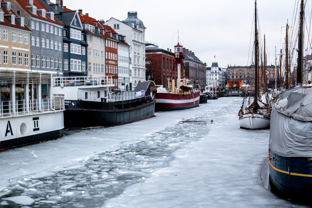 several boats are docked in a frozen canal