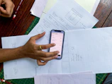 a person holding a cell phone on top of a table