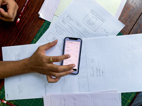 a person holding a cell phone on top of a table