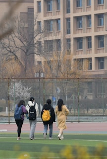 a group of people walking across a field