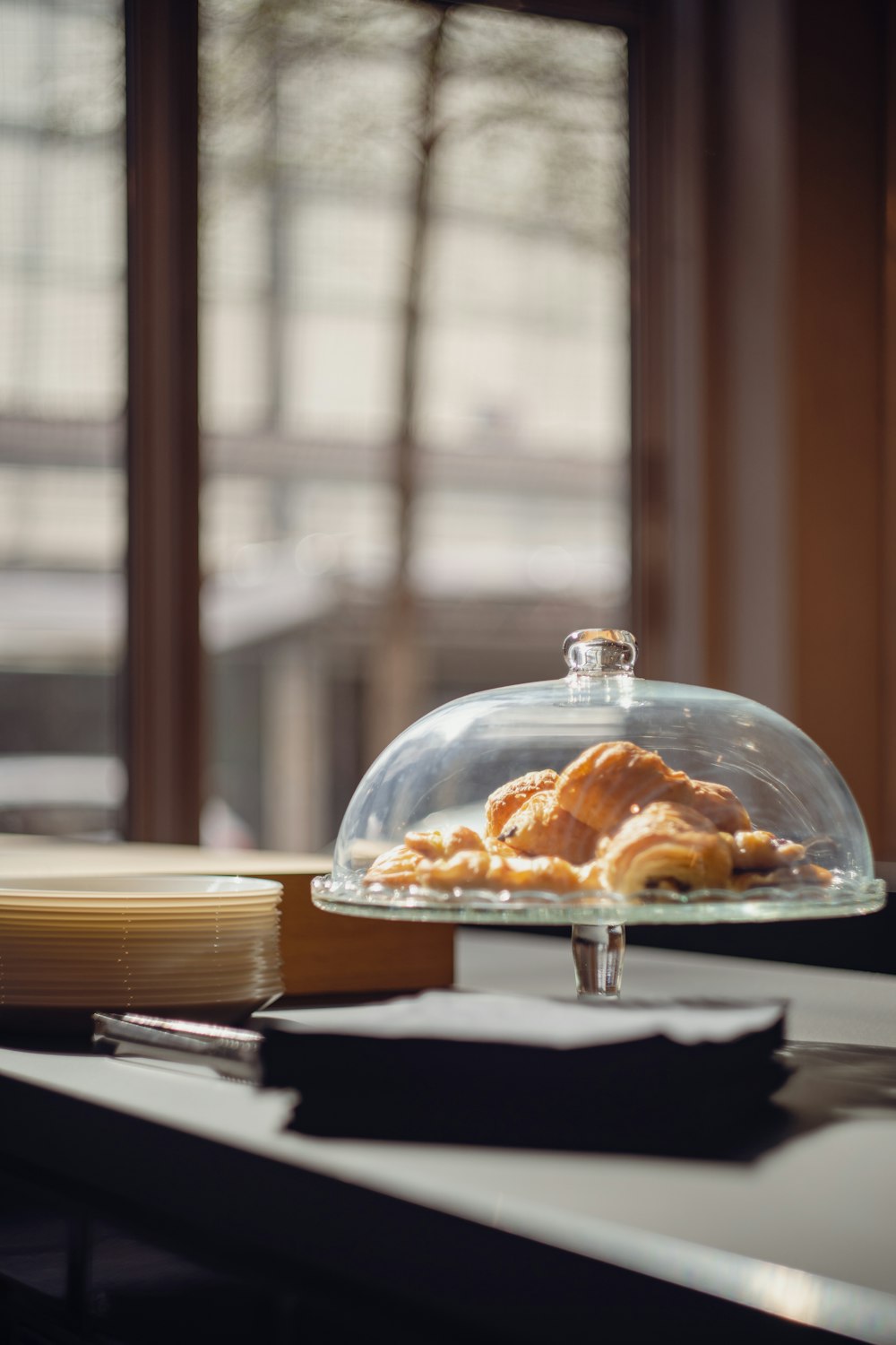 um clochel de vidro coberto com comida sentada em cima de uma mesa