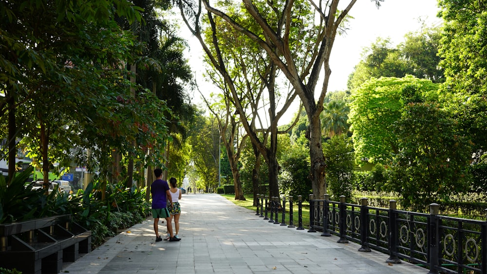 a couple of people that are standing on a sidewalk