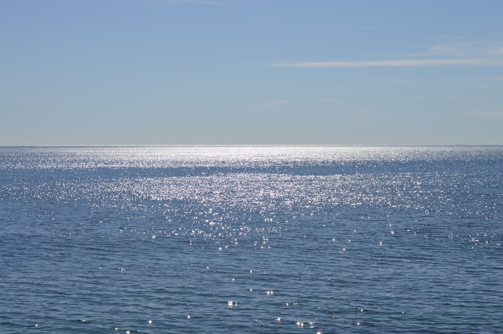 a large body of water sitting under a blue sky