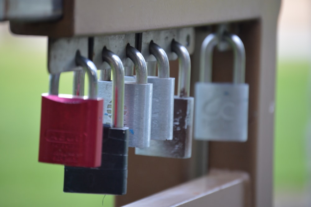 a bunch of padlocks are hanging on a wall