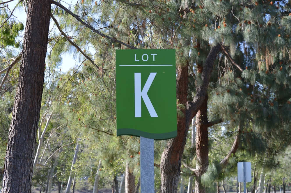 uma placa de rua verde sentada no meio de uma floresta