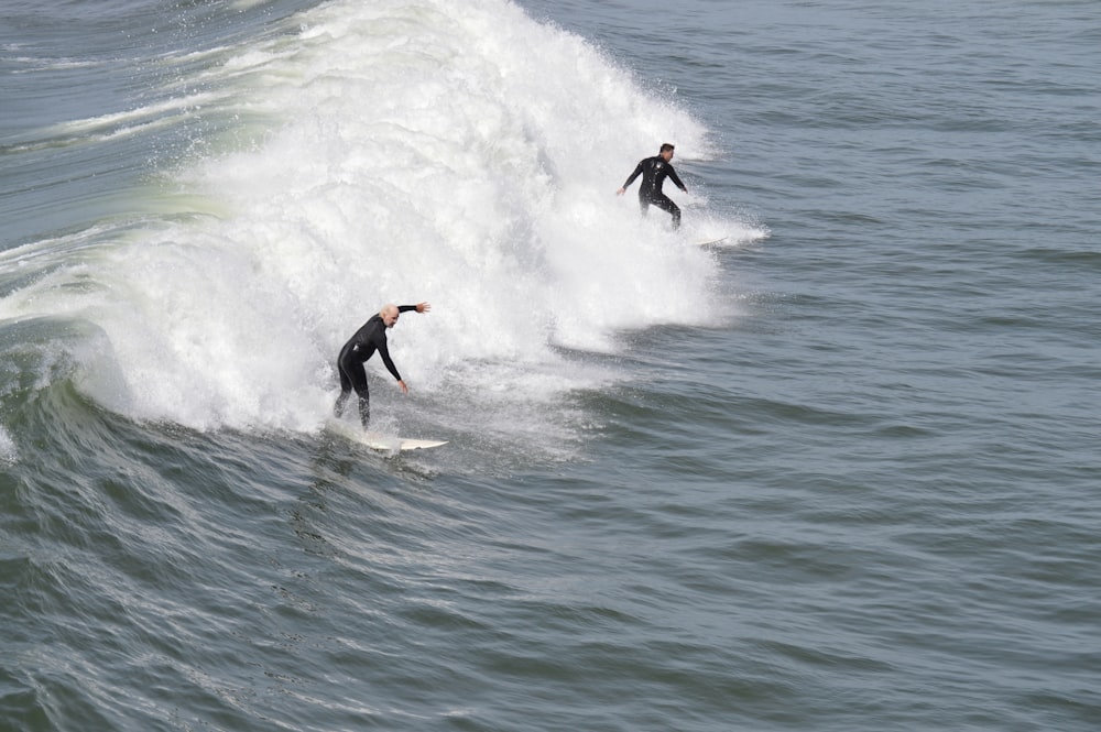 two surfers are riding a wave in the ocean