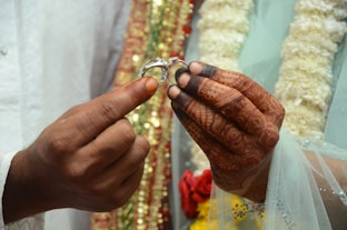 a man is holding a wedding ring in his hands