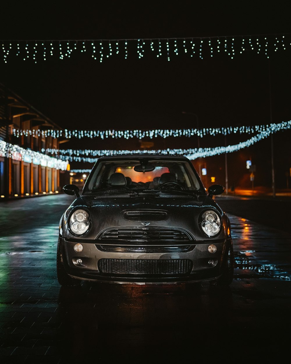 a car parked in front of a building covered in christmas lights