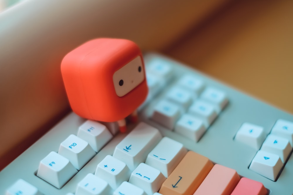 a toy is sitting on top of a computer keyboard
