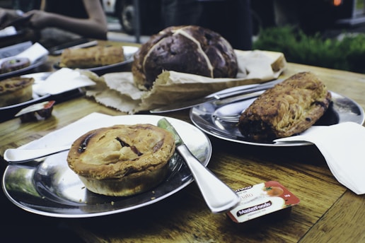 a wooden table topped with plates of food