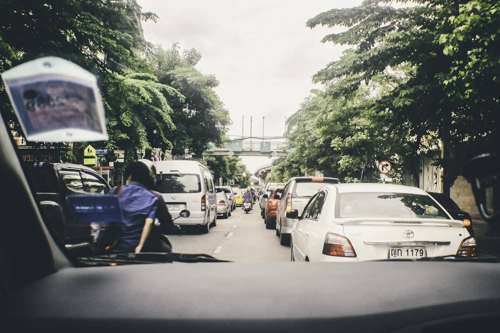 a street filled with lots of traffic next to tall trees