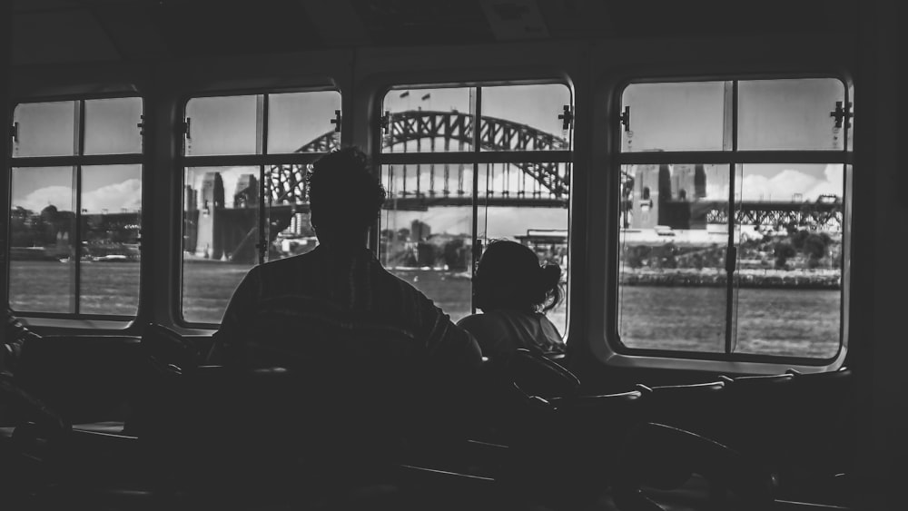 a man and a little girl looking out a window