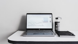 A clean, minimal desk setup with a laptop showing the citrina agency dashboard.