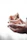 Close-up of a hand scooping dark jaggery pieces from a rustic bowl