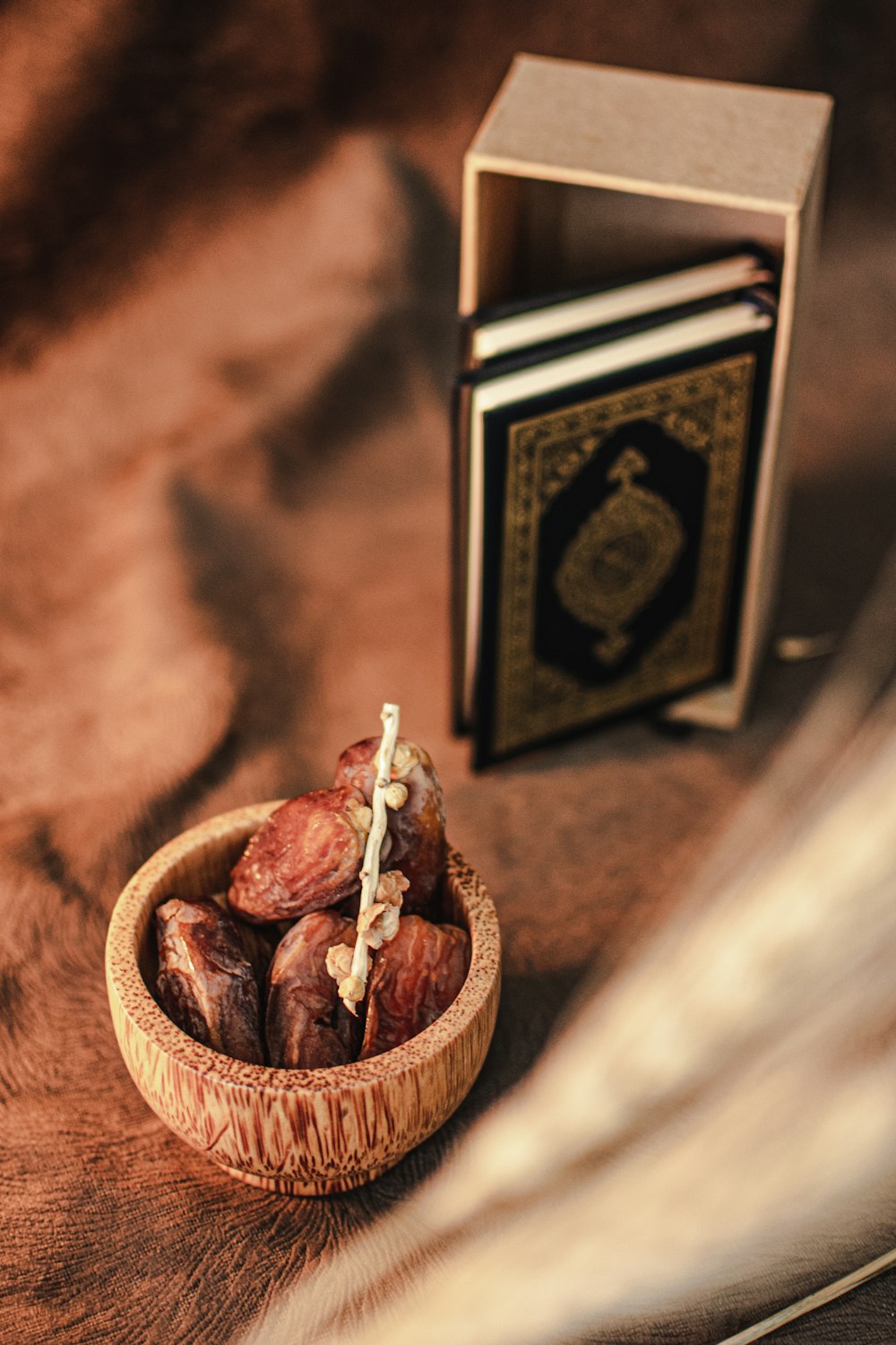 a wooden bowl filled with nuts next to a book