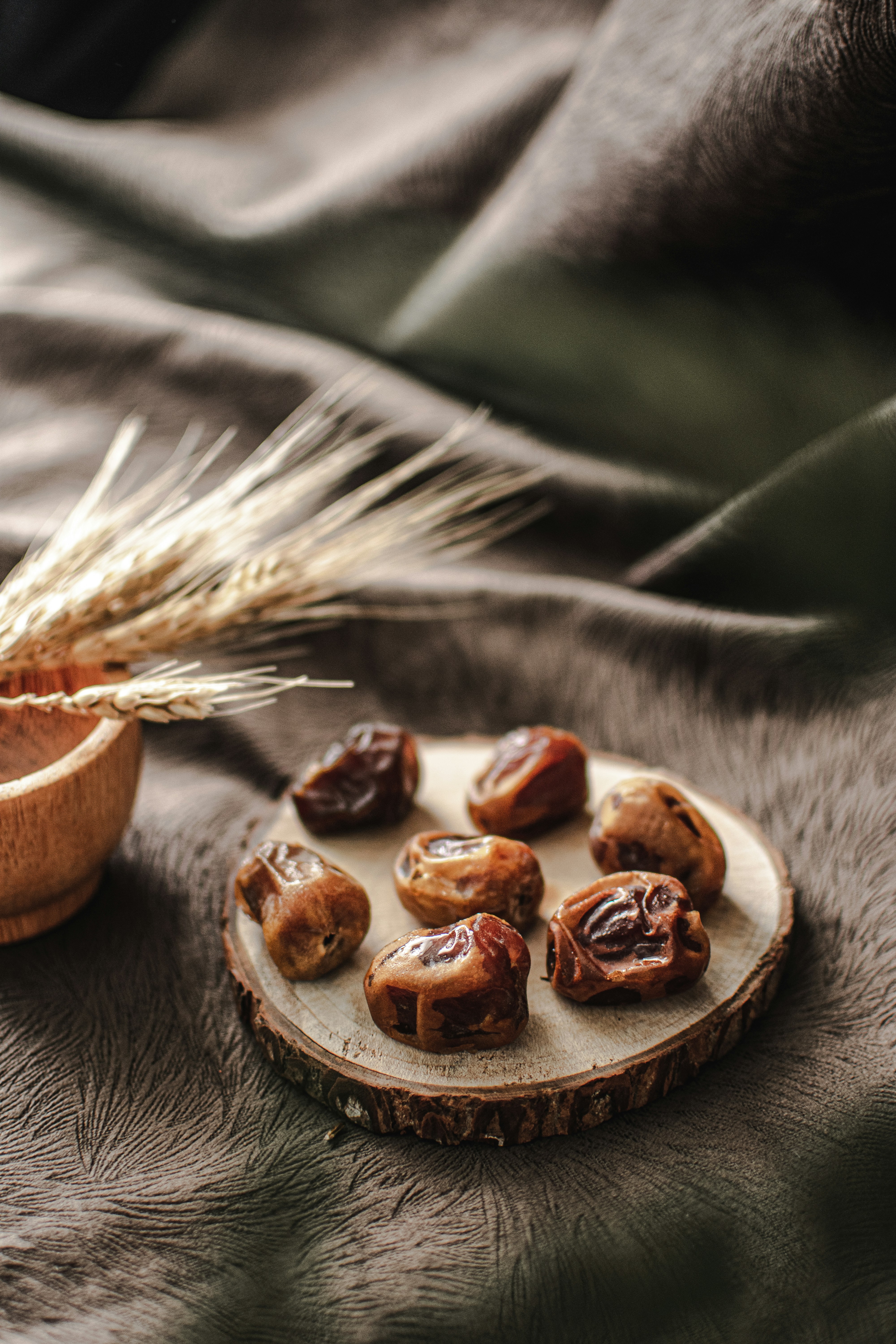a plate of nuts and a bowl of grain on a bed