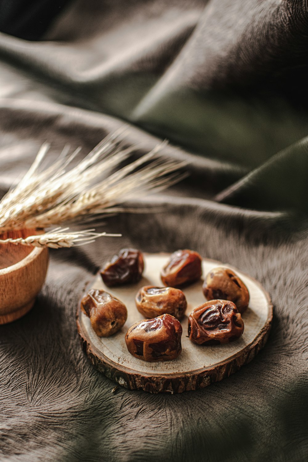 a plate of nuts and a bowl of grain on a bed