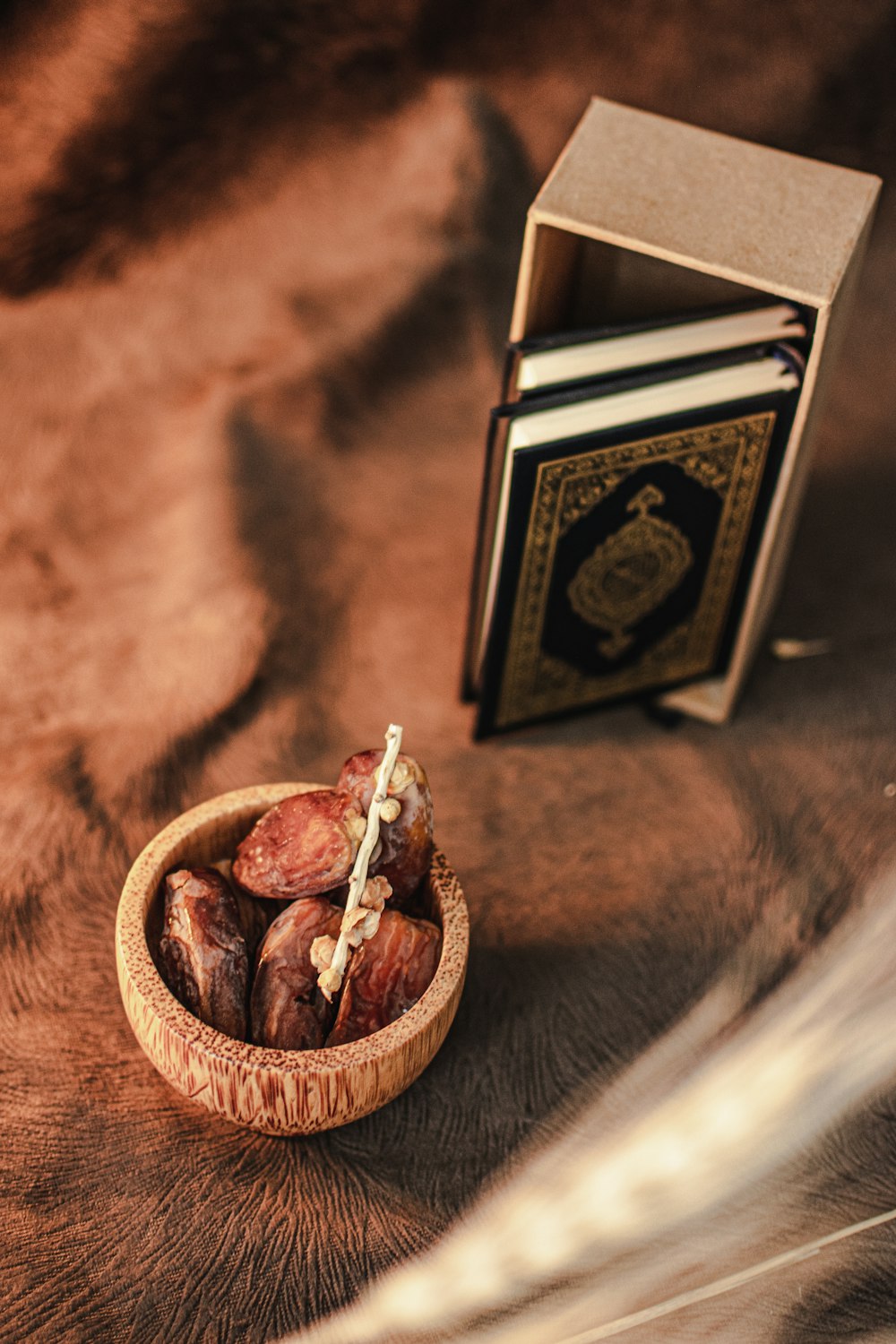 a wooden bowl filled with nuts next to a book