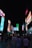 A bustling outdoor urban scene at night, featuring numerous large electronic billboards displaying advertisements. The area is crowded with people walking and socializing on a pedestrian street, and colorful screens illuminate the surroundings.