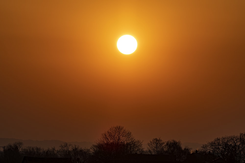 the sun is setting in the sky over a field