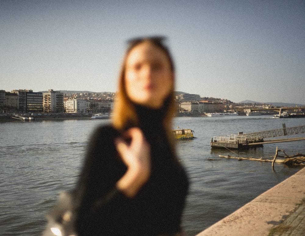 a woman standing next to a body of water