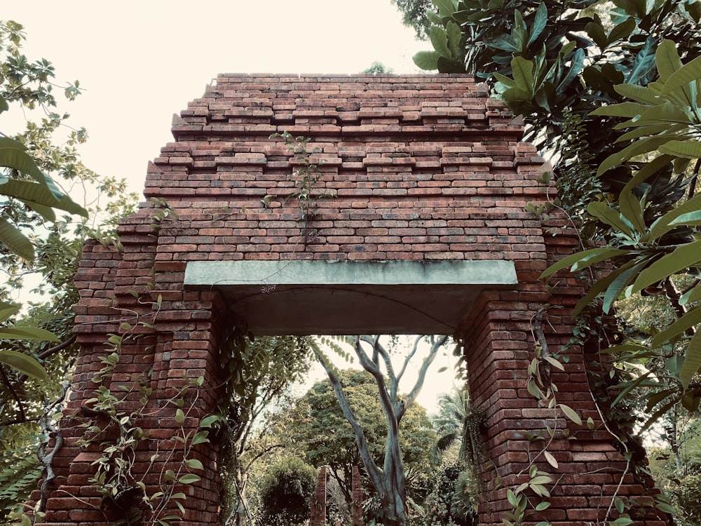 a brick structure with a green roof surrounded by trees