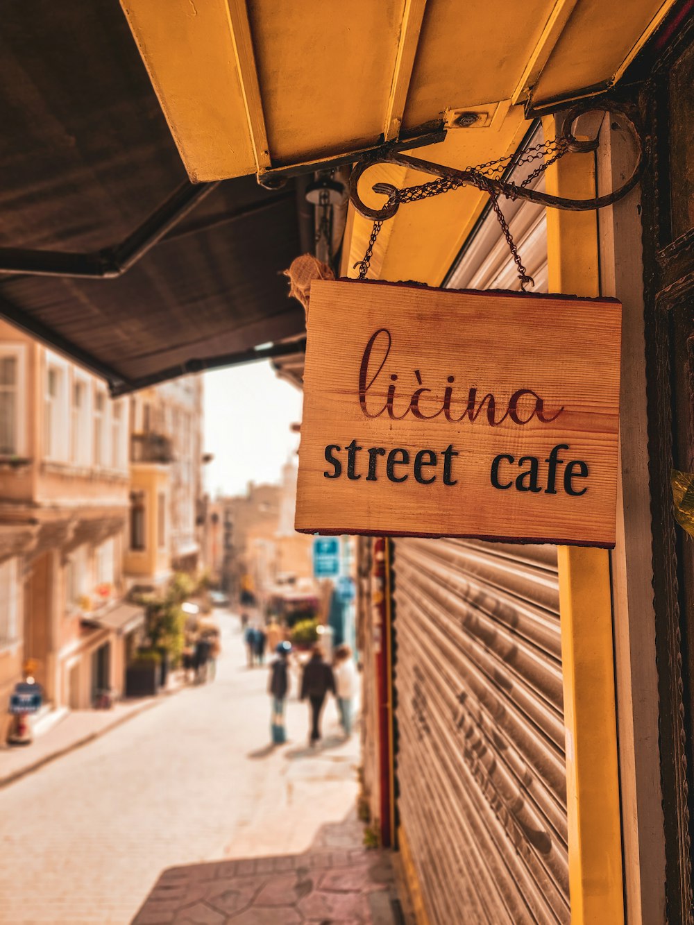 a wooden sign hanging from the side of a building