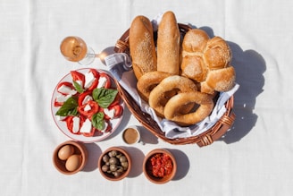 a basket filled with bread next to bowls of food