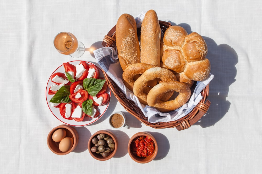 a basket filled with bread next to bowls of food