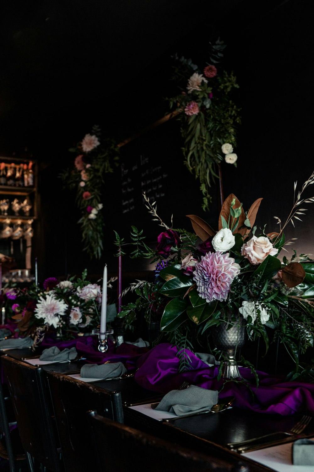une longue table avec des fleurs violettes et blanches dessus