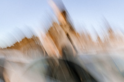 An abstract, blurry motion effect with soft, blended colors and indistinct shapes.
