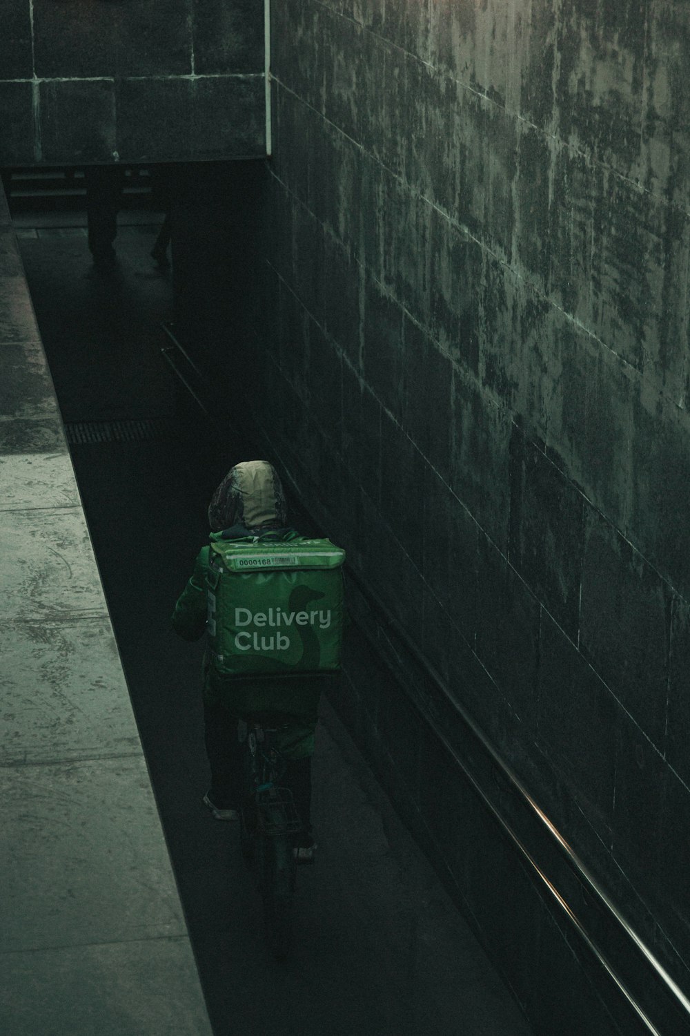 a person riding a bike with a delivery box on the back of it