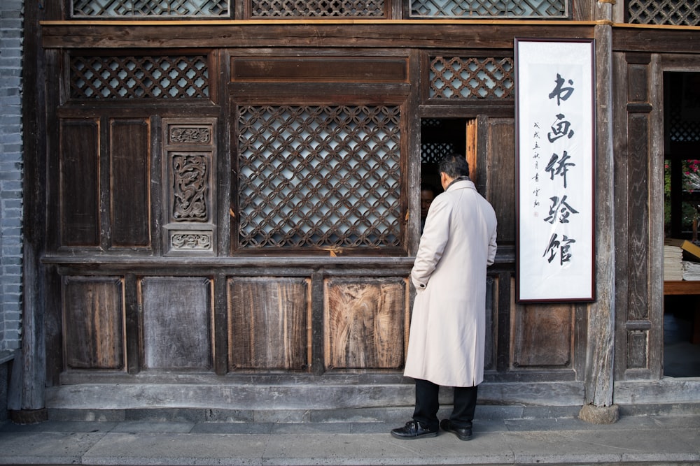 a man standing in front of a wooden building