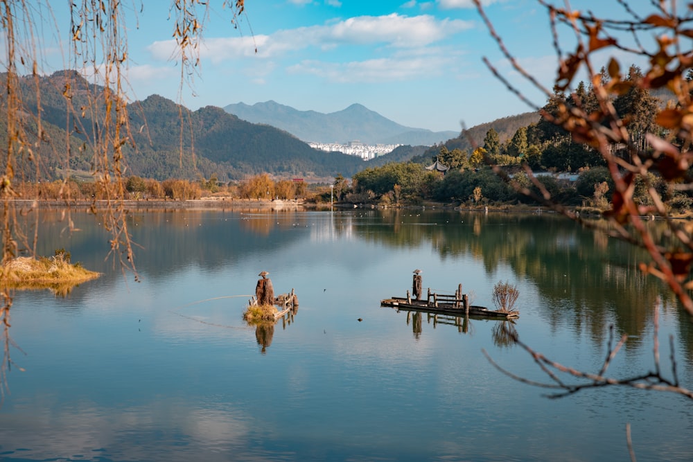 a man fishing on a lake surrounded by mountains