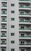 Modern residential building with dark green accents and smooth rounded balconies.