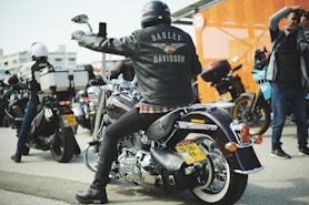 a man sitting on a motorcycle in a parking lot