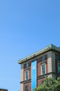 a tall building with a blue sign hanging off the side of it