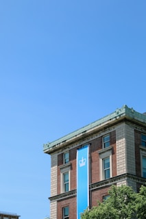 a tall building with a blue sign hanging off the side of it
