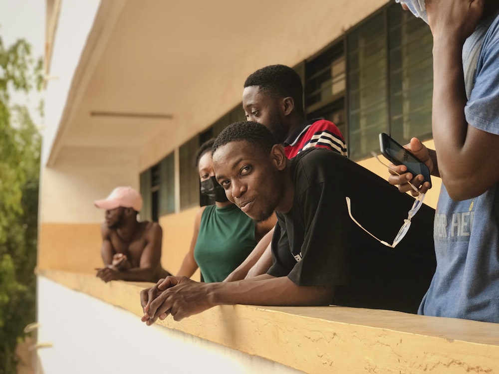 a group of people sitting on the side of a building