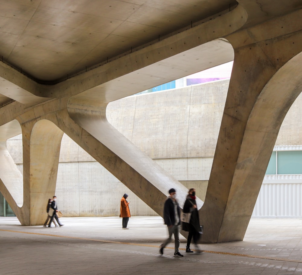 a group of people walking under a bridge