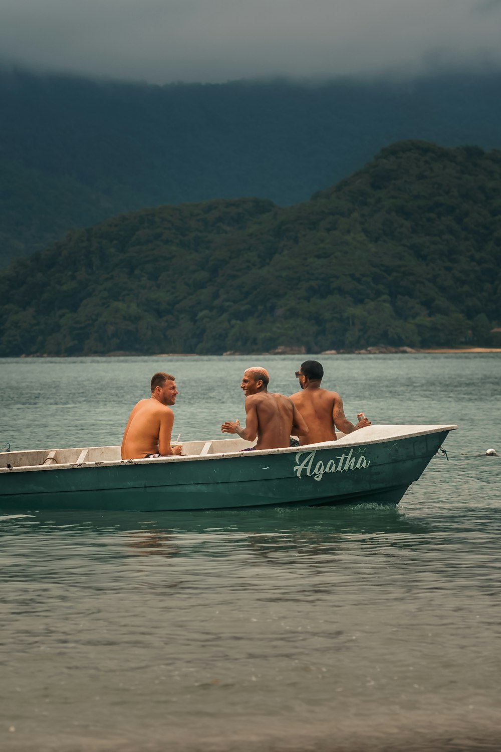 three men in a small boat on the water