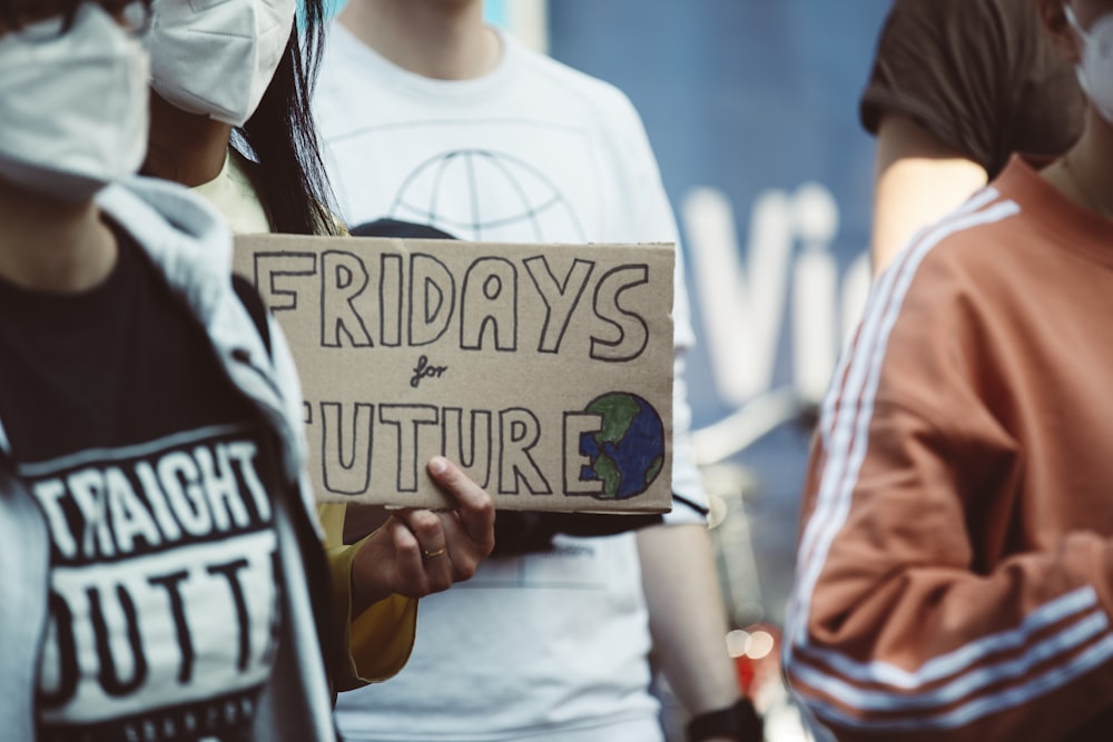 a person holding a sign that says friday's for future