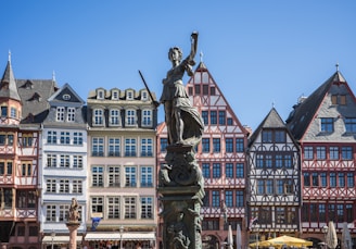 a statue in front of a row of buildings